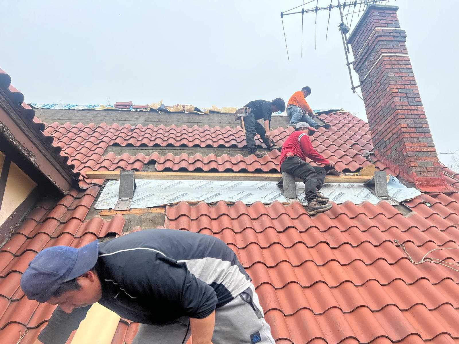 JACOC roofing crew replacing tile and underlayment on a residential roof